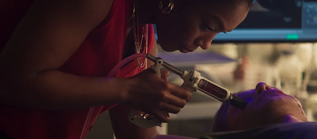 Naomi Ackie as scientist Caitlyn Corr injecting Matt Hagen during the experiment in Clayface